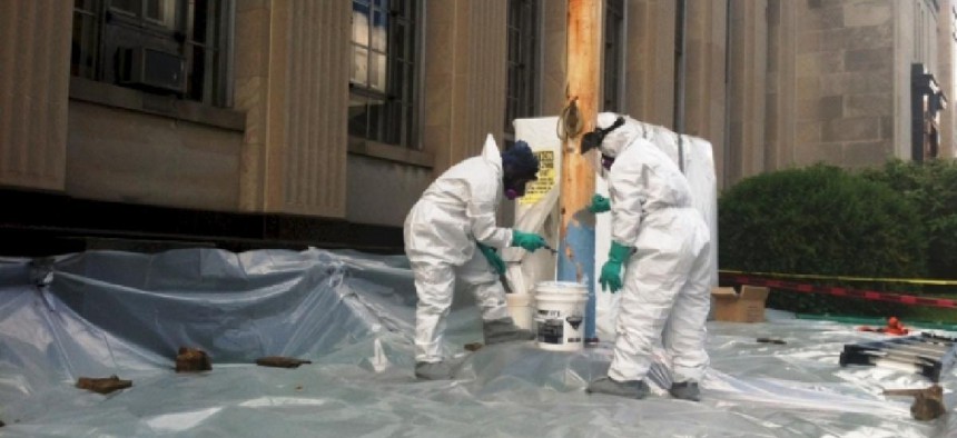 Employees from Environmental Health Control remove lead paint. Image provided