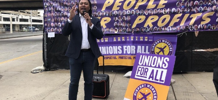 SEIU members and state Rep. Malcolm Kenyatta speak outside the American Airlines terminal.