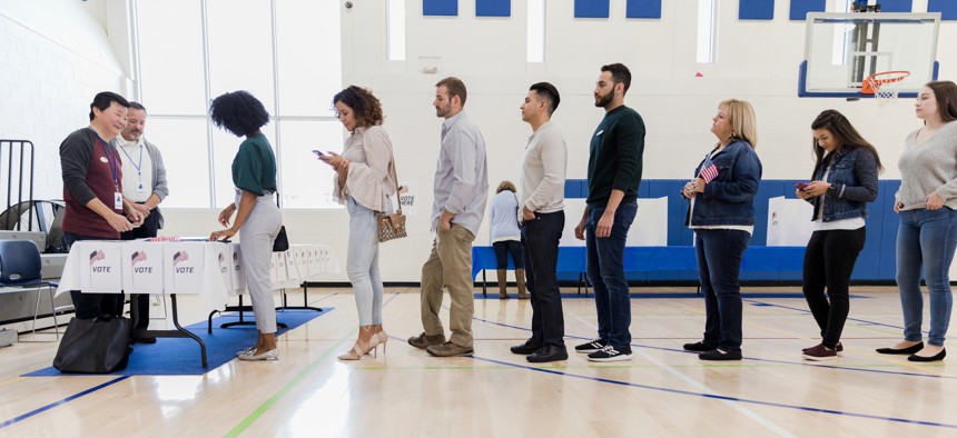 A long line of people wait to vote in poling place.