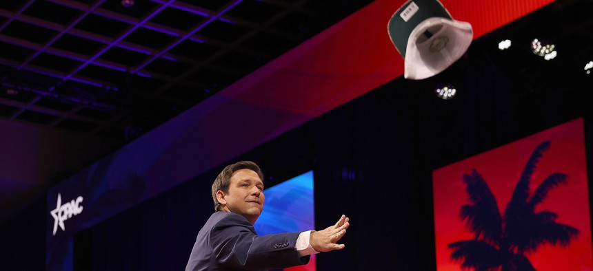 Florida Gov. Ron DeSantis tosses a hat to the crowd before speaking at the Conservative Political Action Conference (CPAC) in Orlando this February.