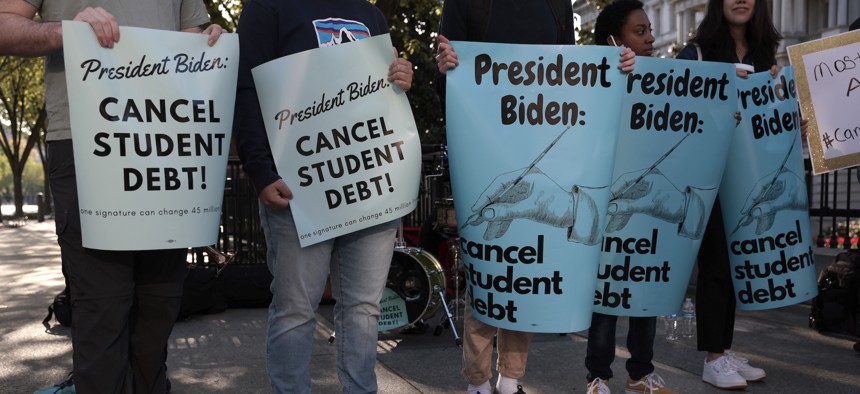 Activists hold signs as they attend a Student Loan Forgiveness rally on Pennsylvania Avenue and 17th Street near the White House.