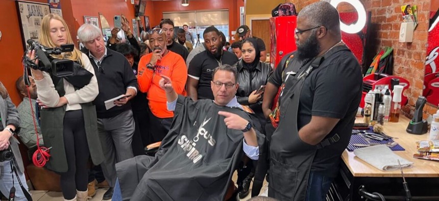 Democratic gubernatorial candidate Josh Shapiro gets a trim — and an earful — from the crowd at Philly Cuts, a barber Shop in West Philadelphia on Saturday.