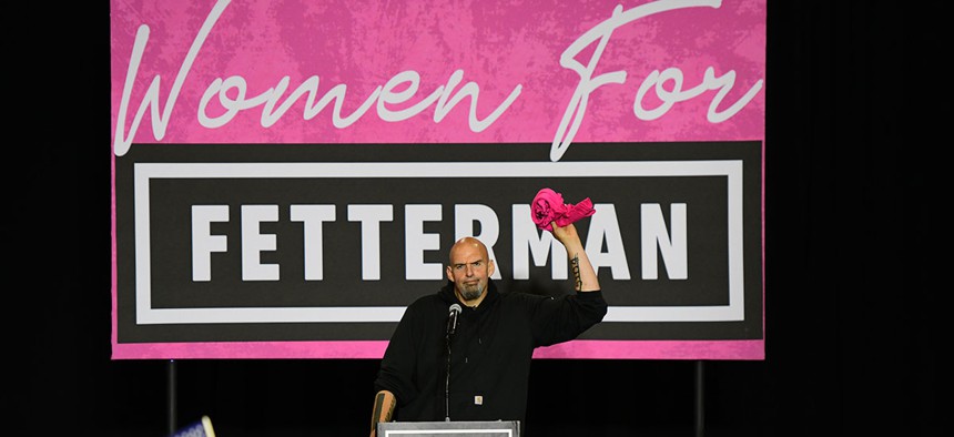 Democratic Senate nominee John Fetterman prepares to throw a t-shirt during a September rally.
