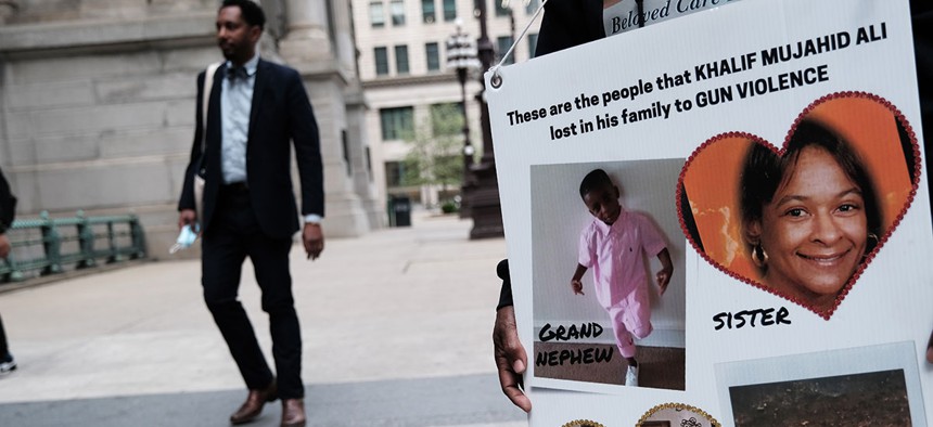 Local teenagers hold up pictures of people killed by guns in April in Philadelphia.