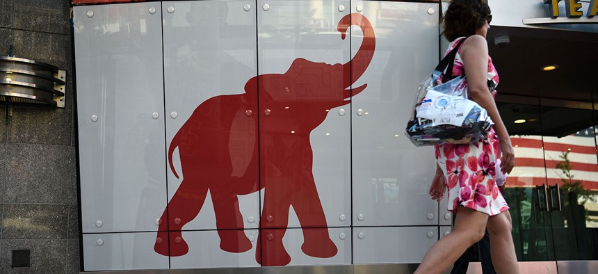 A woman walks past the elephant logo of the Republican Party.