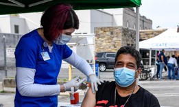 A nurse gives a man a dose of the COVID-19 vaccine during a mobile clinic setup in Reading in April 2021.