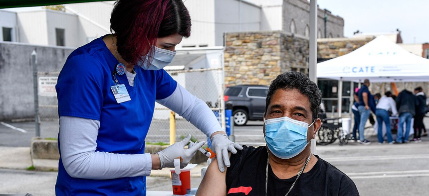 A nurse gives a man a dose of the COVID-19 vaccine during a mobile clinic setup in Reading in April 2021.