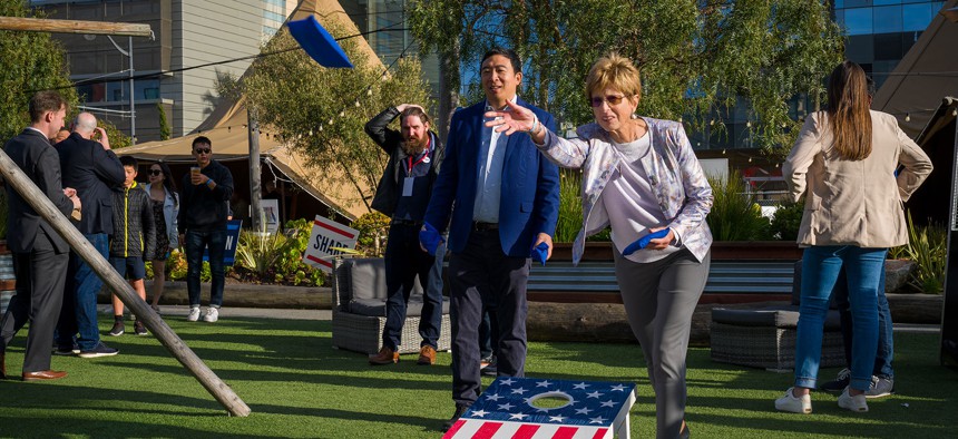 Christine Todd Whitman and fellow Forward co-chair Andrew Yang play cornhole at an event.