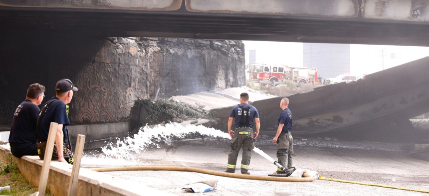Firefighters work at a collapsed portion of Interstate 95, caused by a large vehicle fire, in Philadelphia, Pennsylvania on June 11, 2023.