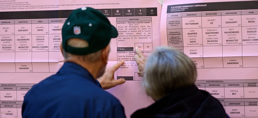 Voters review choices before casting their ballots at a Philadelphia polling location.
