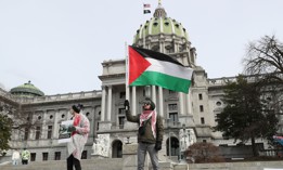 A protester holds a Palestinian flag during the Healthcare Workers for Palestine Rally on the steps of the Pennsylvania State Capitol.