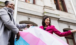Landau, R, and Celena Morrison-McLean, executive director of the city’s Office of LGBT Affairs at Philadelphia City Hall with a transgender pride flag.