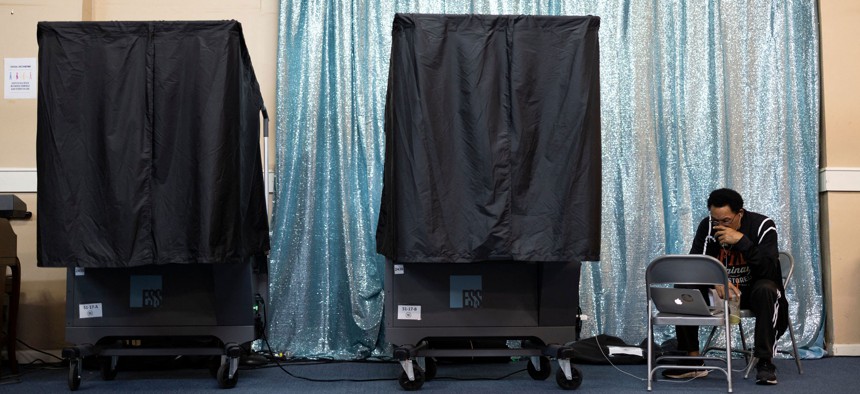 A poll worker, sits next to voting booths on the day of US midterm election in Philadelphia, Pennsylvania, on November 8, 2022.