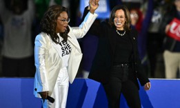 Oprah Winfrey holds up US Vice President and Democratic presidential candidate Kamala Harris' hand as she arrive onstage during a campaign rally on the Benjamin Franklin Parkway in Philadelphia, Pennsylvania, on November 4, 2024.