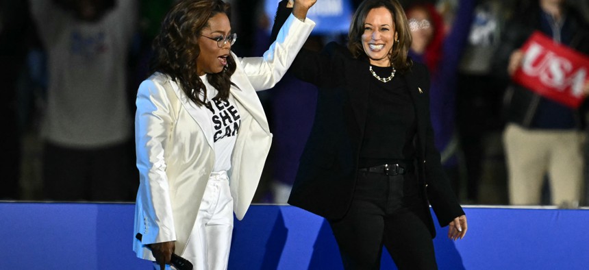 Oprah Winfrey holds up US Vice President and Democratic presidential candidate Kamala Harris' hand as she arrive onstage during a campaign rally on the Benjamin Franklin Parkway in Philadelphia, Pennsylvania, on November 4, 2024.