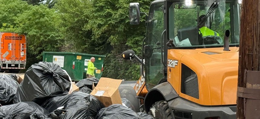 City workers clear the trash-strewn 5000 block of Wyalusing Avenue in West Philadelphia.