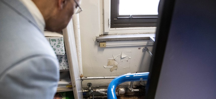 State Sen. Vincent Hughes inspects a water-damaged bathroom inside a Philadelphia school