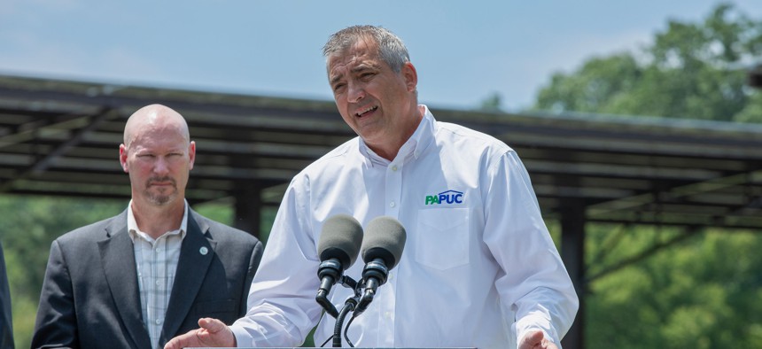 PUC Chair Stephen DeFrank speaks at a 2025 press conference about solar energy.