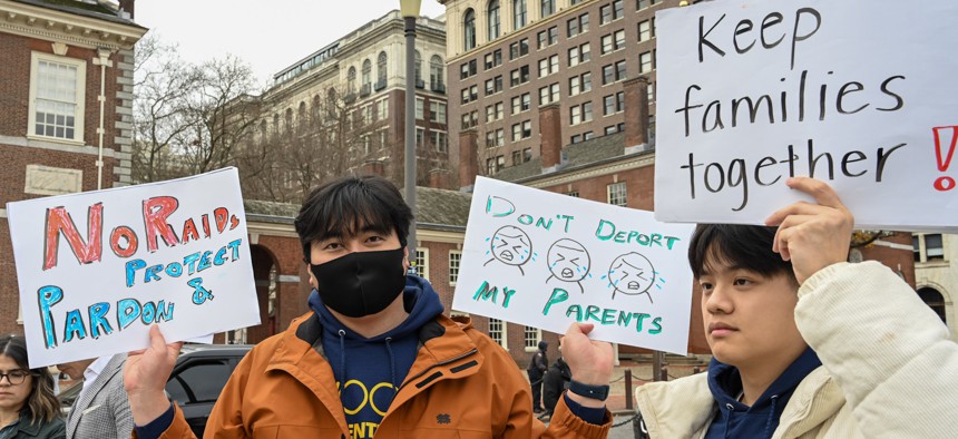 Attendees at a Philadelphia march in support of immigrants hold signs to protest deportations.