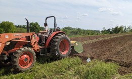A worker prepping land at Root Mass Farm