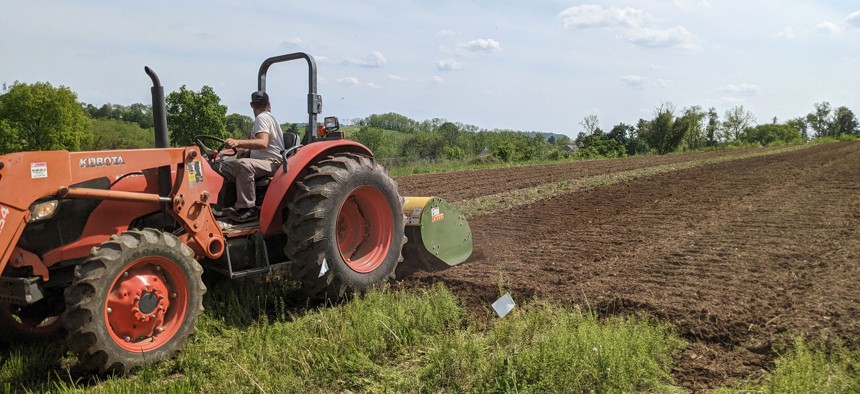 A worker prepping land at Root Mass Farm