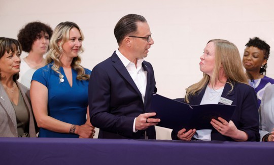 Gov. Josh Shapiro speaks with YWCA Carlisle & Cumberland County Board Member Andrea Greene at a ceremonial bill signing.