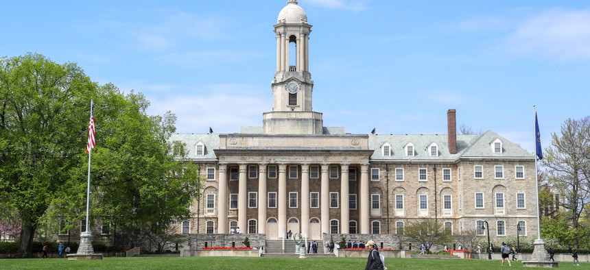 Students walk by Old Main at Pennsylvania State University.