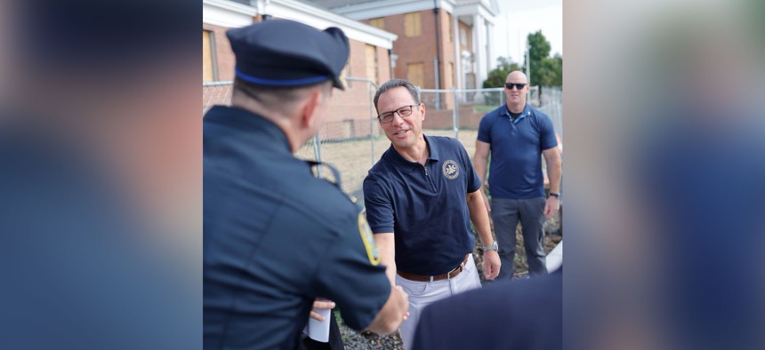 Gov. Josh Shapiro shakes hands with a police officer during an event in Montgomery County.